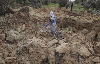 Children check site targeted by Israeli air strikes in Gaza