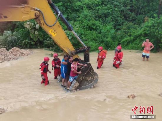 6月16日，因遭遇暴雨袭击，广西沿海多处发生严重内涝，居民被困。当地消防部门接到求助信息后，先后转移被困的居民数十人。图为利用铲车运送被困居民。