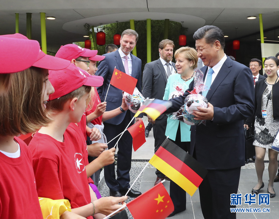 7月5日，国家主席习近平同德国总理默克尔共同出席柏林动物园大熊猫馆开馆仪式。这是习近平向现场的孩子们赠送大熊猫毛绒玩具。 新华社记者谢环驰 摄